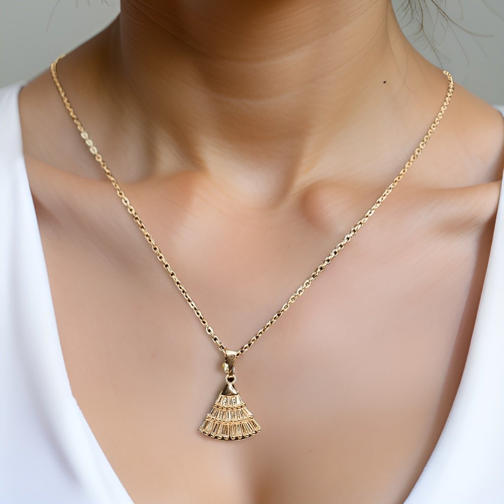 Make a statement with our Fan Pendant. This unique piece features a fan-shaped pendant that adds a touch of intrigue to any ensemble. The adjustable chain ensures a perfect fit, making it suitable for all necklines.