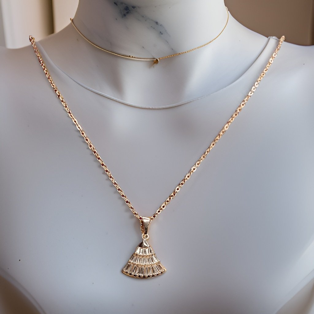 Make a statement with our Fan Pendant. This unique piece features a fan-shaped pendant that adds a touch of intrigue to any ensemble. The adjustable chain ensures a perfect fit, making it suitable for all necklines.